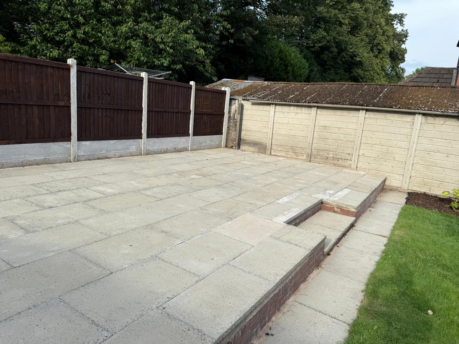 Flagged patio finished up to the edge of a lawn
