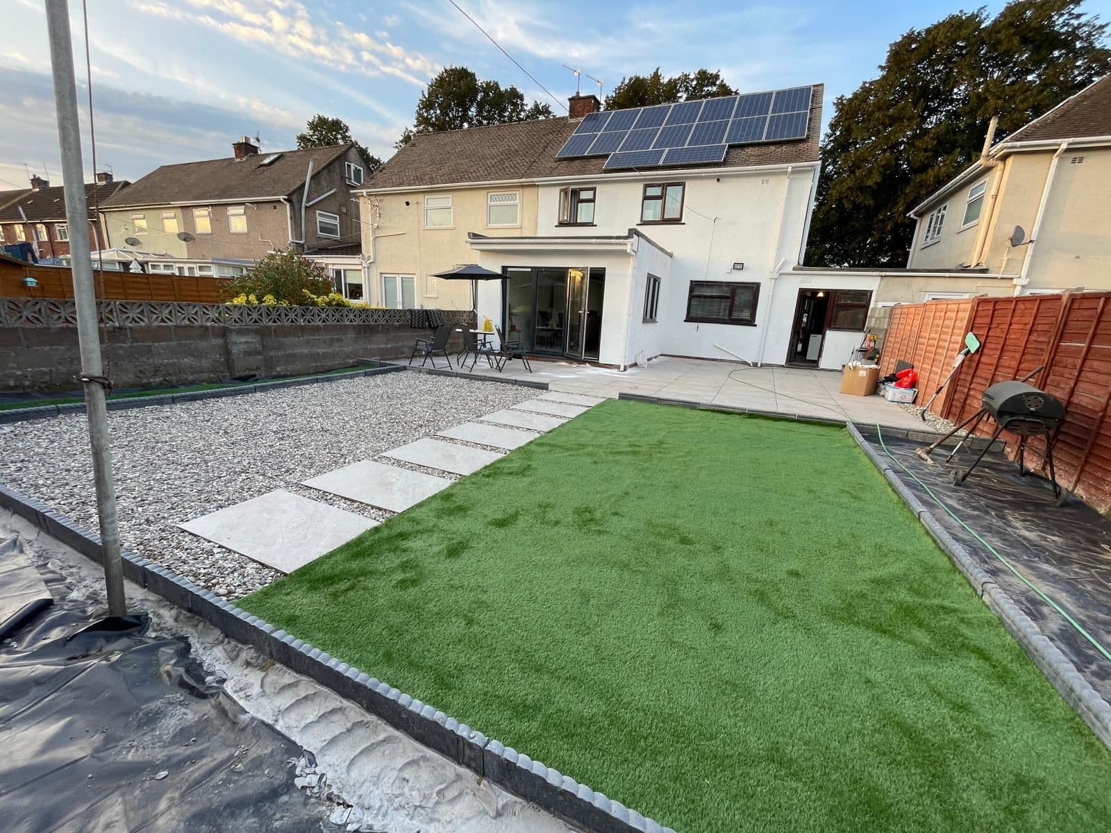 Artificial grass lawn laid to a clean edge against paving