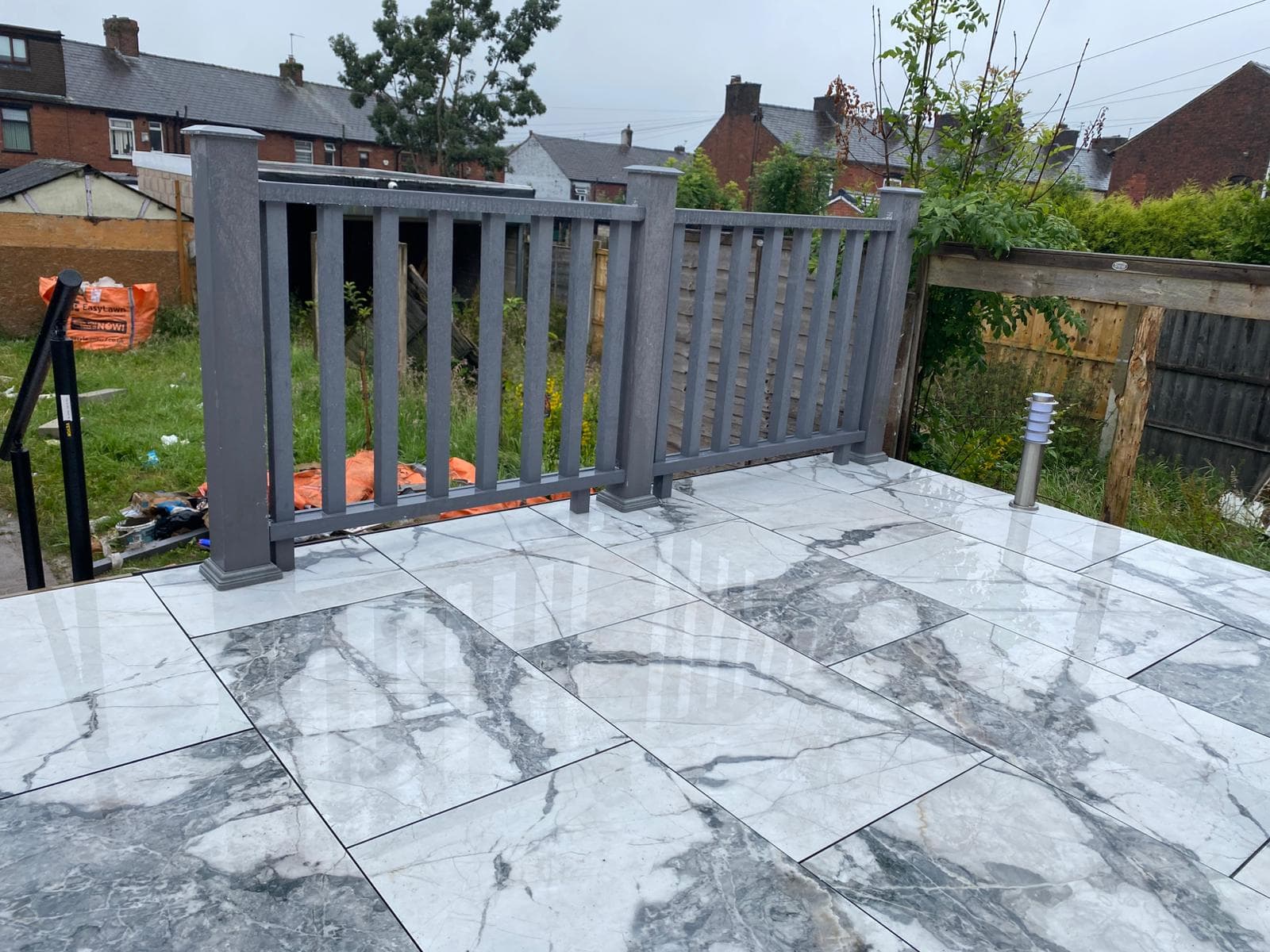 Wide porcelain patio finished up to a new lawn